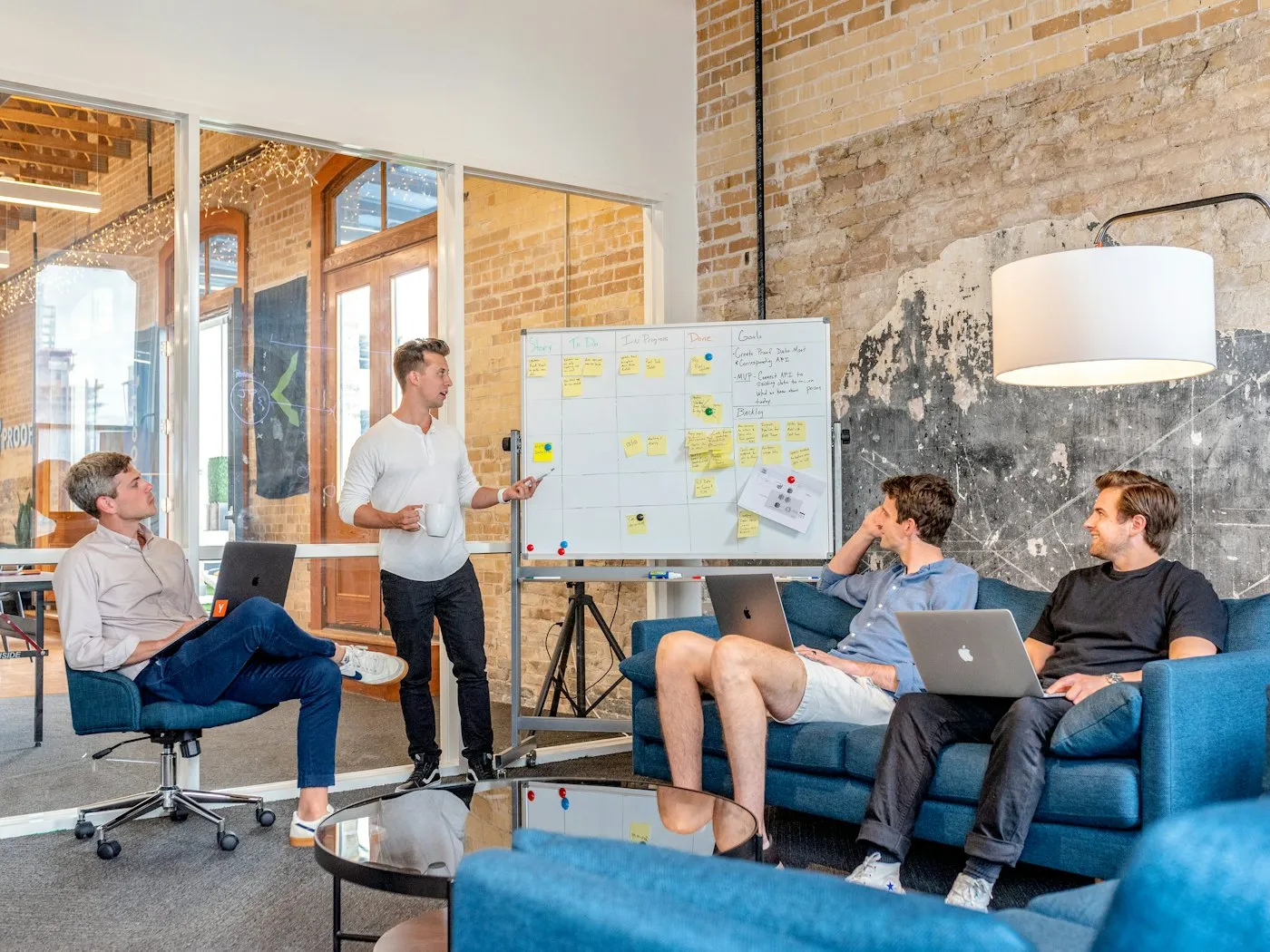 Team gathered in a meeting room around a wall of sticky notes during a planning workshop
