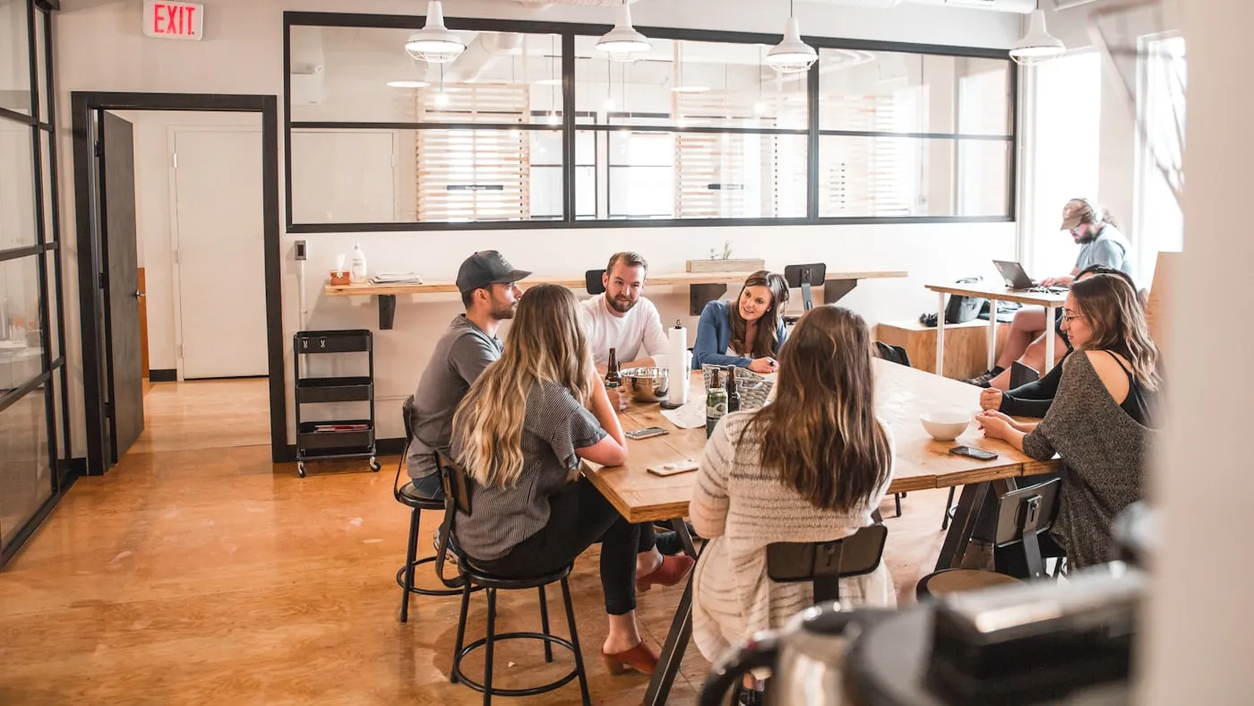 Colleagues working at long tables in a bright open-plan office