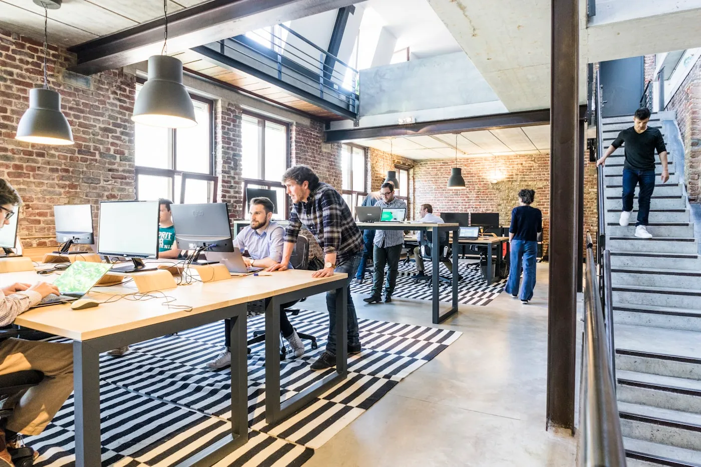 People working in a converted loft office with large windows