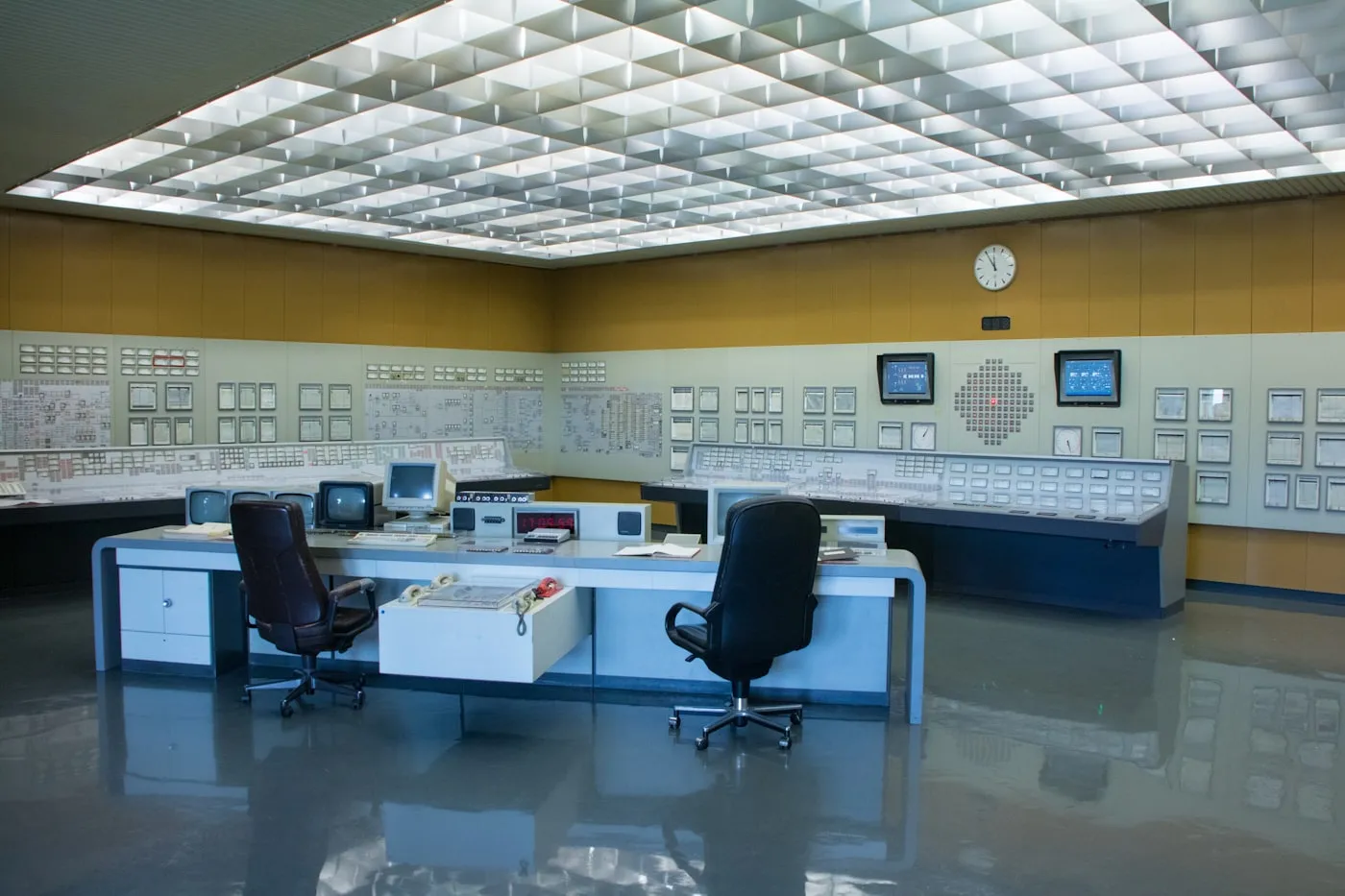 Utility control room with operator consoles and wall instrument panels
