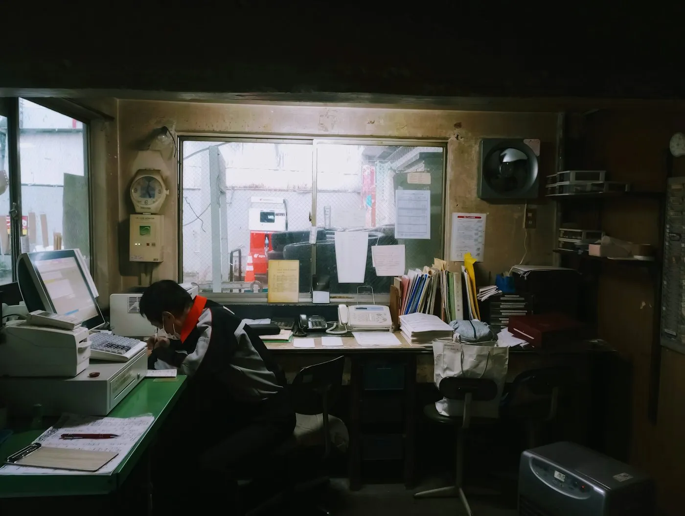 Desk with several computer screens and paperwork in use